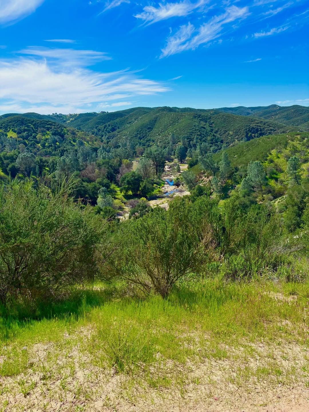 Green valley and ridgelines under a blue sky at Granite Ridge
